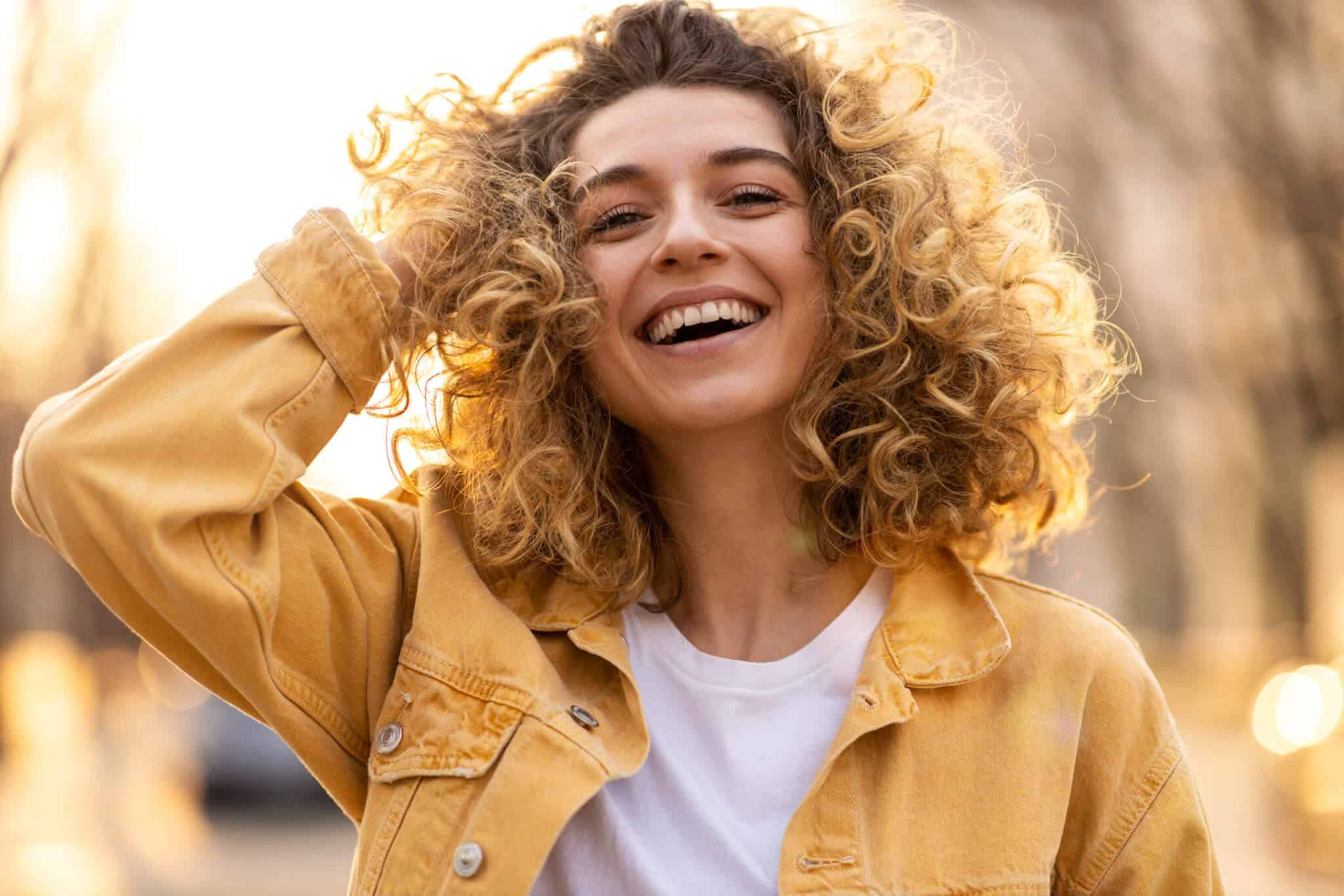 Woman with Curly Hair Moved by the Wind | Sheperd Integrative Dermatology in Mount Pleasant, SC